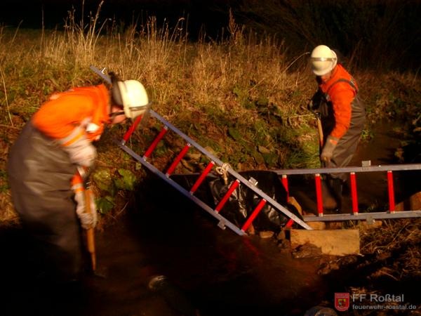 Bild 4 von 10 Mit Leitern, Folie und viel Schlamm wird der Bach aufgestaut .